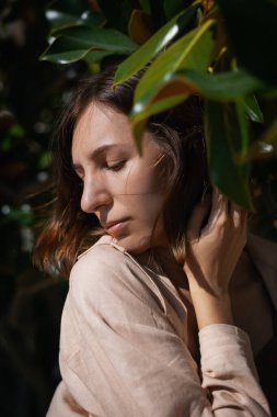 Tropikal bitkilerin arasında gülen neşeli bir kız.. 