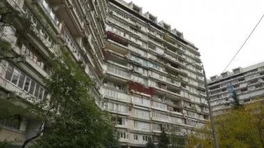 Sıra dışı balkonları olan yüksek katlı bir binanın ön cephesi. Alışılmadık bir ev. Alt manzara. Doli kamera görüntüsü