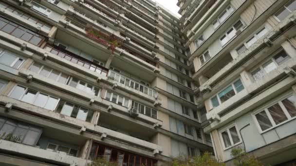 La fachada de un edificio residencial alto con balcones inusuales. Una casa inusual. Vista de abajo. Dolly cámara de tiro — Vídeo de stock