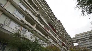 Sıra dışı balkonları olan yüksek katlı bir binanın ön cephesi. Alışılmadık bir ev. Alt manzara. Doli kamera görüntüsü