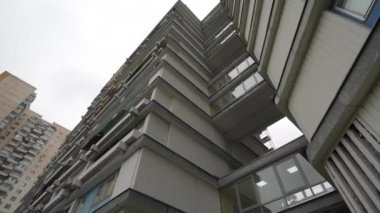 Yüksek bir konut binasında alışılmadık balkonlar, aşağıdan manzara. Binanın garip geometrisi. Doli kamera görüntüsü