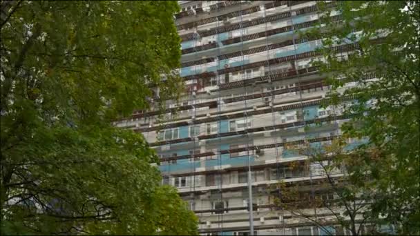 Andamios al lado de un edificio residencial de gran altura. El andamio se utiliza como plataforma de trabajo para los trabajadores. Cámara Dolly — Vídeo de stock