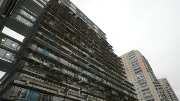 Ponteggi a lato di un grattacielo residenziale. Il ponteggio è utilizzato come piattaforma di lavoro per i lavoratori. Macchina fotografica Dolly — Video Stock