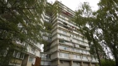 Yüksek bir konut binasında alışılmadık balkonlar, aşağıdan manzara. Binanın garip geometrisi. Doli kamera. 