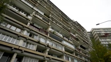 Sıra dışı balkonları olan yüksek katlı bir binanın ön cephesi. Alışılmadık bir ev. Alt manzara. Doli kamera.