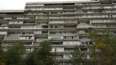 Sıra dışı balkonları olan yüksek katlı bir binanın ön cephesi. Alışılmadık bir ev. Alt manzara. Doli kamera görüntüsü