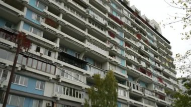 Sıra dışı balkonları olan yüksek katlı bir binanın ön cephesi. Alışılmadık bir ev. Alt manzara. Doli kamera görüntüsü