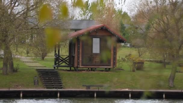 Domki kempingowe nad jeziorem w jesienny dzień. strzelanie ręczne — Wideo stockowe