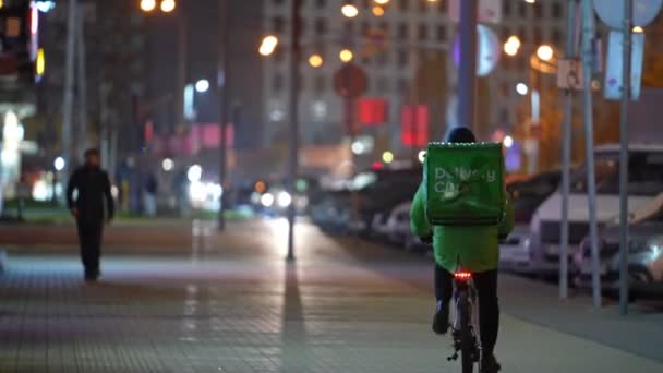 Moscow, Russia- october 2021: The courier on a bicycle goes to make delivery at night. 손을 잡고 — 비디오