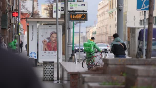 Moskva, Rusko-listopad 2021: Kurýr v zelených kombinézách na kole jede na podzim doručit jídlo. odstraněno z rukou — Stock video