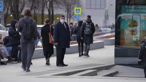 Москва, Росія-листопад 2021: Дуже товстий чоловік у діловому костюмі та з медичною маскою на обличчі на жвавій вулиці. — стокове відео