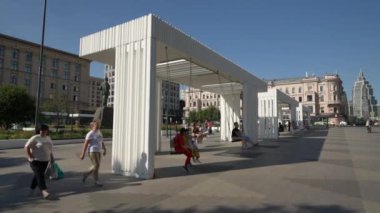 Moskova 'daki Mayakovsky Meydanı' ndaki tecritten sonra insanlar dikkatsizce salıncakta sallanıyor. Hareket halinde çekim
