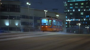 Kış, gece şehir manzarası modern tramvaylar kışın köprüden geçiyor.
