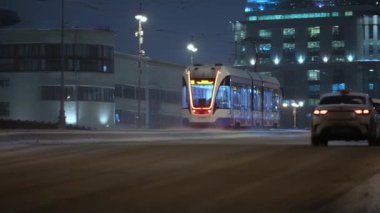 Kış, gece şehir manzarası modern tramvaylar kışın köprüden geçiyor.