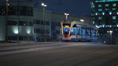 Kış, gece şehir manzarası modern tramvaylar kışın köprüden geçiyor.