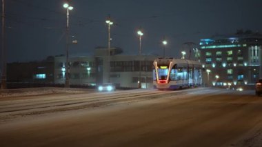Kış, gece şehir manzarası modern tramvaylar kışın köprüden geçiyor.
