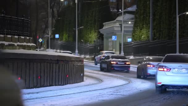 Moskou, Rusland-december 2021: Een moderne tram rijdt door een nachtstraat tijdens sneeuwval in de winter. — Stockvideo