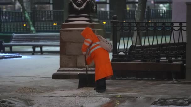 Moszkva, Oroszország - december 2021: Este egy ember havat fúj egy ásóval Moszkva utcáin. — Stock videók