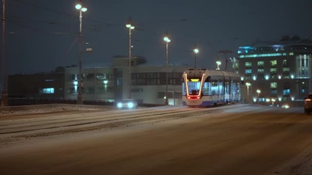 Winter, nacht stadsgezicht moderne tram rijdt over de brug in de winter — Stockvideo