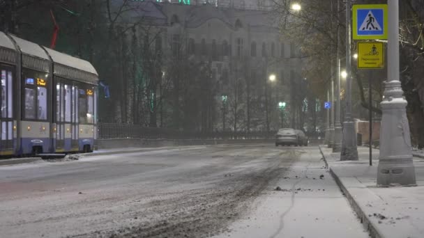 Москва, Росія-вересень 2021: Сучасний трамвай їде нічною вулицею під час снігопаду.. — стокове відео
