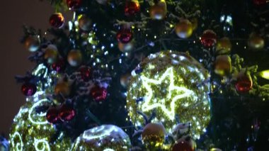 Şehirdeki Noel ağacında parlayan oyuncaklar. Akşam vakti. Doldur.