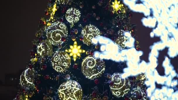 Natal brinquedos brilhantes na árvore de Natal da cidade à noite na cidade. Clouse. — Vídeo de Stock