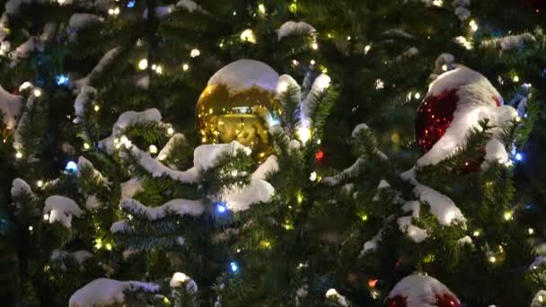 Vánoce zářící hračky na městském vánočním stromečku ve večerních hodinách ve městě. Rozepnout — Stock video