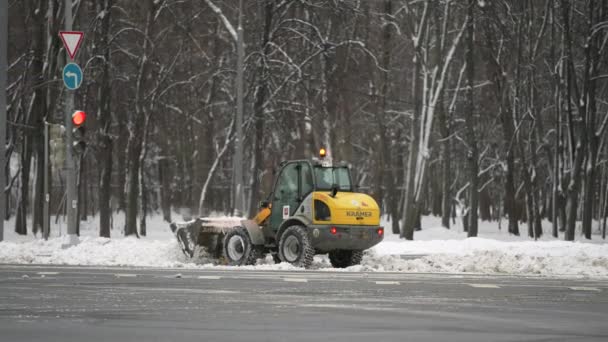 Москва, Россия - декабрь 2021: Желтый снегоочиститель убирает снег после сильного снегопада в городе в течение дня — стоковое видео