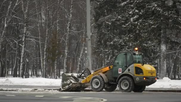 Μόσχα, Ρωσία- Δεκέμβριος 2021: Κίτρινο εκχιονιστικό εκχιονιστικό απομακρύνει το χιόνι μετά από έντονη χιονόπτωση στην πόλη κατά τη διάρκεια της ημέρας — Αρχείο Βίντεο