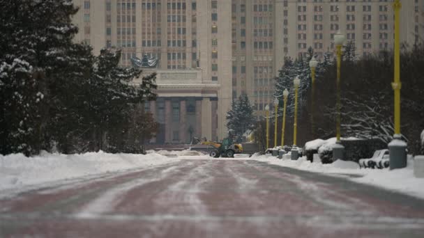 El quitanieves amarillo elimina la nieve después de fuertes nevadas en la ciudad durante el día — Vídeos de Stock