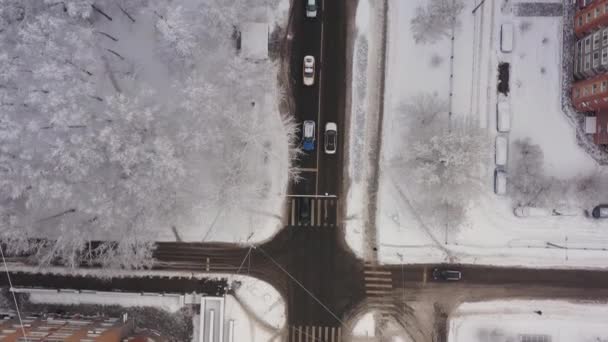 Una macchina taxi attraversa le strade innevate della città dopo una nevicata. Le strade della città sono coperte di neve. Vista aerea — Video Stock