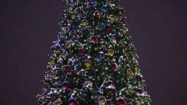 Şehirdeki Noel ağacında parlayan oyuncaklar. Akşam vakti. Doldur.