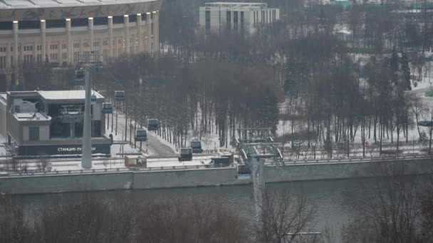 Zimowy krajobraz w Moskwie. Kabiny kolejki linowej w ruchu na tle miasta po opadach śniegu — Wideo stockowe