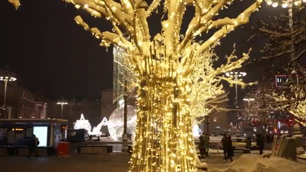 Moskau, Russland-Dezember 2021: Silvesterbeleuchtung auf den Straßen der Stadt, Lichterschmuck im neuen Jahr, Urlaubsansichten auf den Abendstraßen. im Dunkeln. Die Leute gehen und haben Spaß — Stockvideo