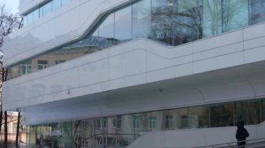 The facade and windows of the modern futuristic building are close-ups of winter. Modern office building. Beautiful business center