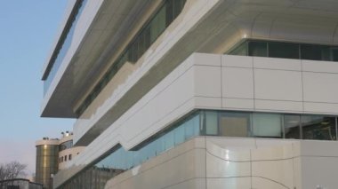 The facade and windows of the modern futuristic building are close-ups of winter. Modern office building. Beautiful business center