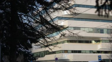 The facade and windows of the modern futuristic building are close-ups of winter. Modern office building. Beautiful business center