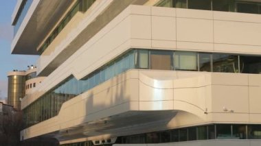 The facade and windows of the modern futuristic building are close-ups of winter. Modern office building. Beautiful business center