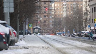 Moscow, Russia - January 2022: A small child runs across the railway breaking traffic rules in the city after a snowfall