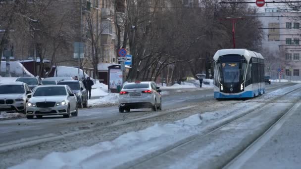Moscow, Russia- January 2022: A modern tram drives through the snow-covered streets of the city after a snowfall — Stock video