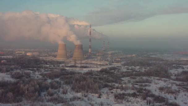 The thermal power plant works at full capacity in the cold winter during the day near the city. Aerial view — Wideo stockowe