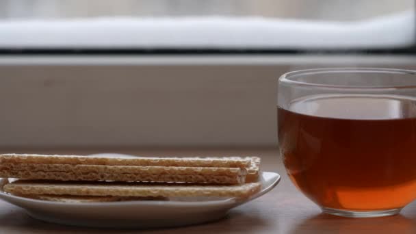 A large mug of tea and diet bread in a plate on the windowsill in winter. The camera is in motion. Selective focus — Stok video