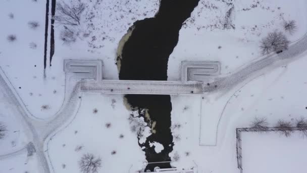 街の歩行者用橋は、人々は冬に川を渡って橋を渡って歩く。空中風景 — ストック動画