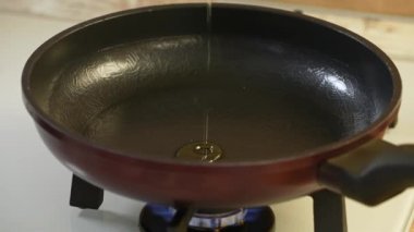 Zeytin yağı siyah bir teflon tavaya dökülür. Yavaş çekim