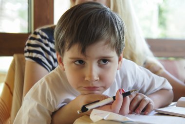 çocuğun ödevlerini yapıyor