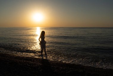 Şafakta sahilde yürüyen yalnız bir kız