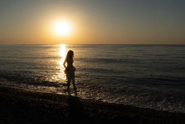 Şafakta sahilde yürüyen yalnız bir kız