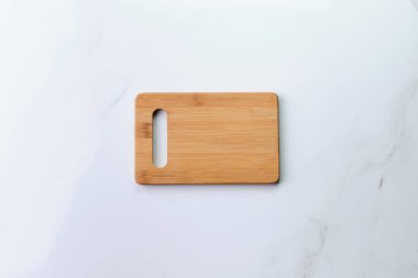 Eski beyaz mermer yüzeyde tahta kesme tahtası. Ürün veya metin için kopyalama alanı olan üst görünüm.