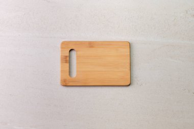 Eski bej mermer yüzeyde tahta kesme tahtası. Ürün veya metin için kopyalama alanı olan üst görünüm.