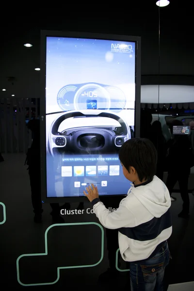 Niño mirando al monitor en el Salón Internacional del Automóvil de Seúl —  Fotos de Stock